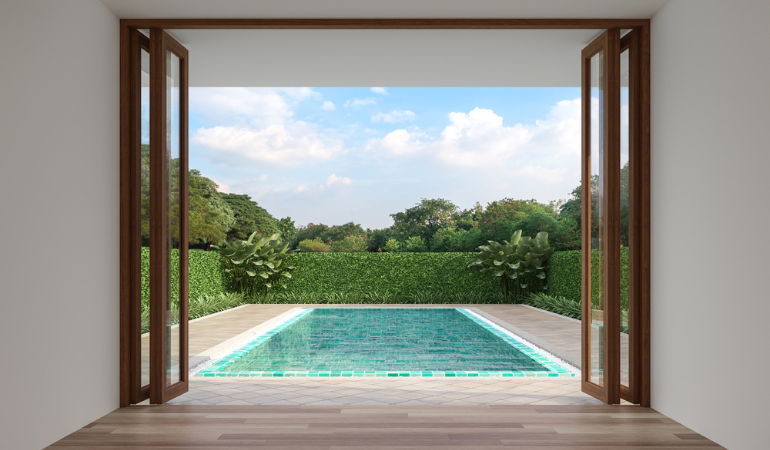 internal shot of bi-fold doors opening onto a terraced pool area
