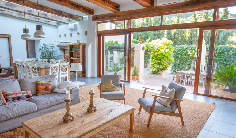 brown sliding doors open, joining a living room with a garden outside