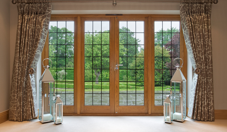brown french doors with floor length curtains which are open either side