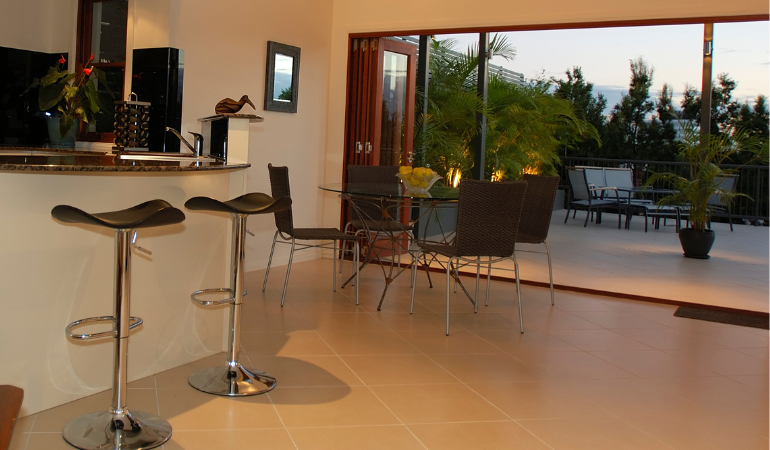 wide bi-fold doors leading from a kitchen area out onto a garden terrace