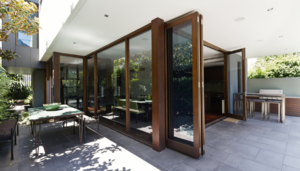 brown external bifold doors, open, leading onto a patio area