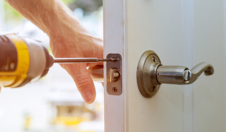 A door handle and locking mechanism being fitted to a door