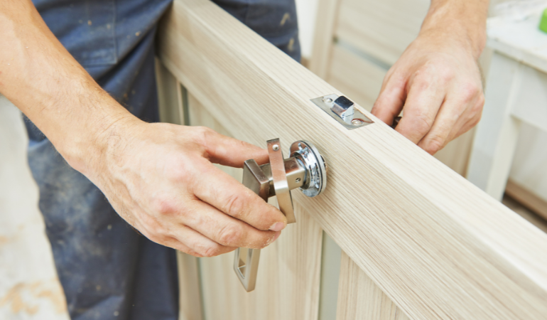 A technician applying new ironmongery to a brand new door before fitting